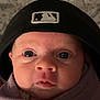 baby, infant, face, headwear, hat, blanket, swaddled, closeup, portrait, skin, eyes, nose, mouth, expression, newborn, child, indoors, soft_light, cute, baby_clothing