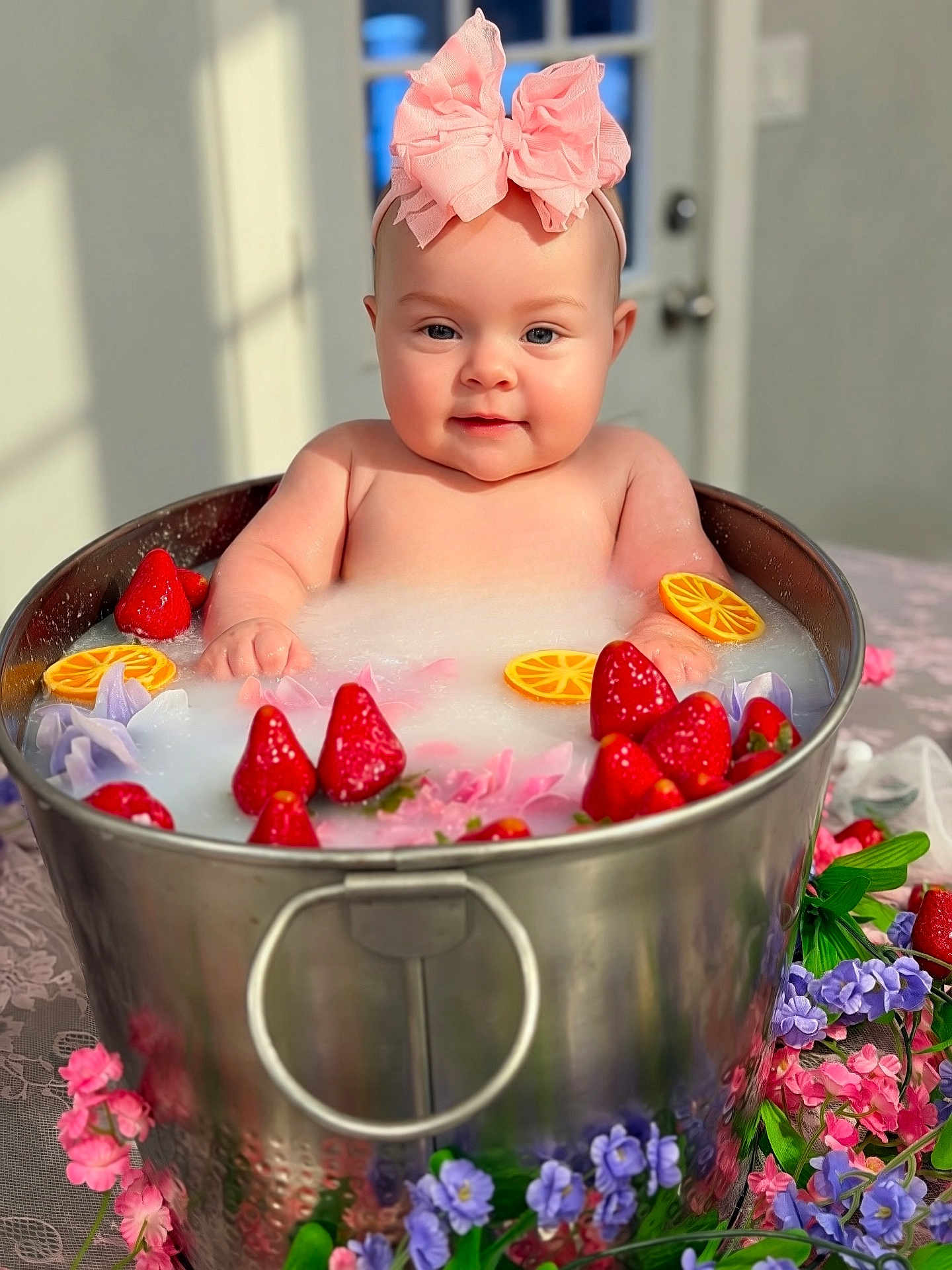 Haven joined the competition — help win amazing prizes! baby, infant, child, headband, bow, milk_bath, tub, metal_bucket, strawberries, orange_slices, flowers, floral, portrait, closeup, smile, rosy_cheeks, indoor, tablecloth, bubble_bath, cute