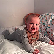 Andrew is registered to the contest to win money with this photo: baby, child, smile, pajamas, bed, blanket, pillow, indoor, happy, infant, cute, face, person, toddler, cozy, lying_down, home, comfort, soft, sleepwear