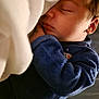 baby, sleeping, infant, blue_clothing, blanket, cozy, peaceful, face, hand, newborn, resting, indoors, soft_light, closeup, portrait, cute, child, toddler, skin, warm