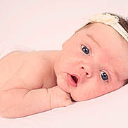 Issabella Rose is registered to the contest to win money with this photo: baby, infant, face, headband, flower, skin, arm, lying_down, cute, portrait, newborn, child, soft_light, expression, closeup, human, resting, peaceful, pink, white_background