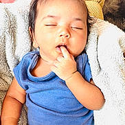 Sri Vamika is registered to the contest to win money with this photo: baby, sleeping, finger_in_mouth, blue_shirt, diaper, blanket, cushion, soft_texture, infant, peaceful, cute, child, indoors, resting, cozy, portrait, skin, hair, hand, relax