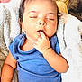 baby, sleeping, finger_in_mouth, blue_shirt, diaper, blanket, cushion, soft_texture, infant, peaceful, cute, child, indoors, resting, cozy, portrait, skin, hair, hand, relax