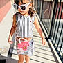 child, girl, sunglasses, striped_clothing, pink_purse, walking, sunlight, shadow, sidewalk, railing, fashion, casual, outdoor, footwear, sneakers, accessories, cute, summer, confident, young