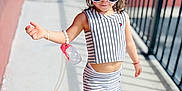 Leah joined the competition — help win amazing prizes! child, toddler, sunglasses, striped_clothing, crop_top, skirt, sneakers, bracelet, sidewalk, sunlight, shadow, fence, urban, fashion, outdoor, person, cute, hair_bow, walking, playful