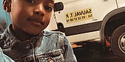 Alfred a rejoint le concours — aidez-le/la à gagner de superbes lots ! child, denim_jacket, vehicle, van, garage, indoor, person, casual, portrait, young, black_hair, smile, clothing, transport, parking, floor, head, face, window, door