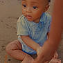 Alfred participe au concours pour gagner de l'argent avec cette photo : baby, child, sitting, sand, blue_shirt, hand, barefoot, outdoor, curious, infant, young_child, portrait, skin, face, legs, wide_eyes, natural_light, casual_clothing, closeup, expression