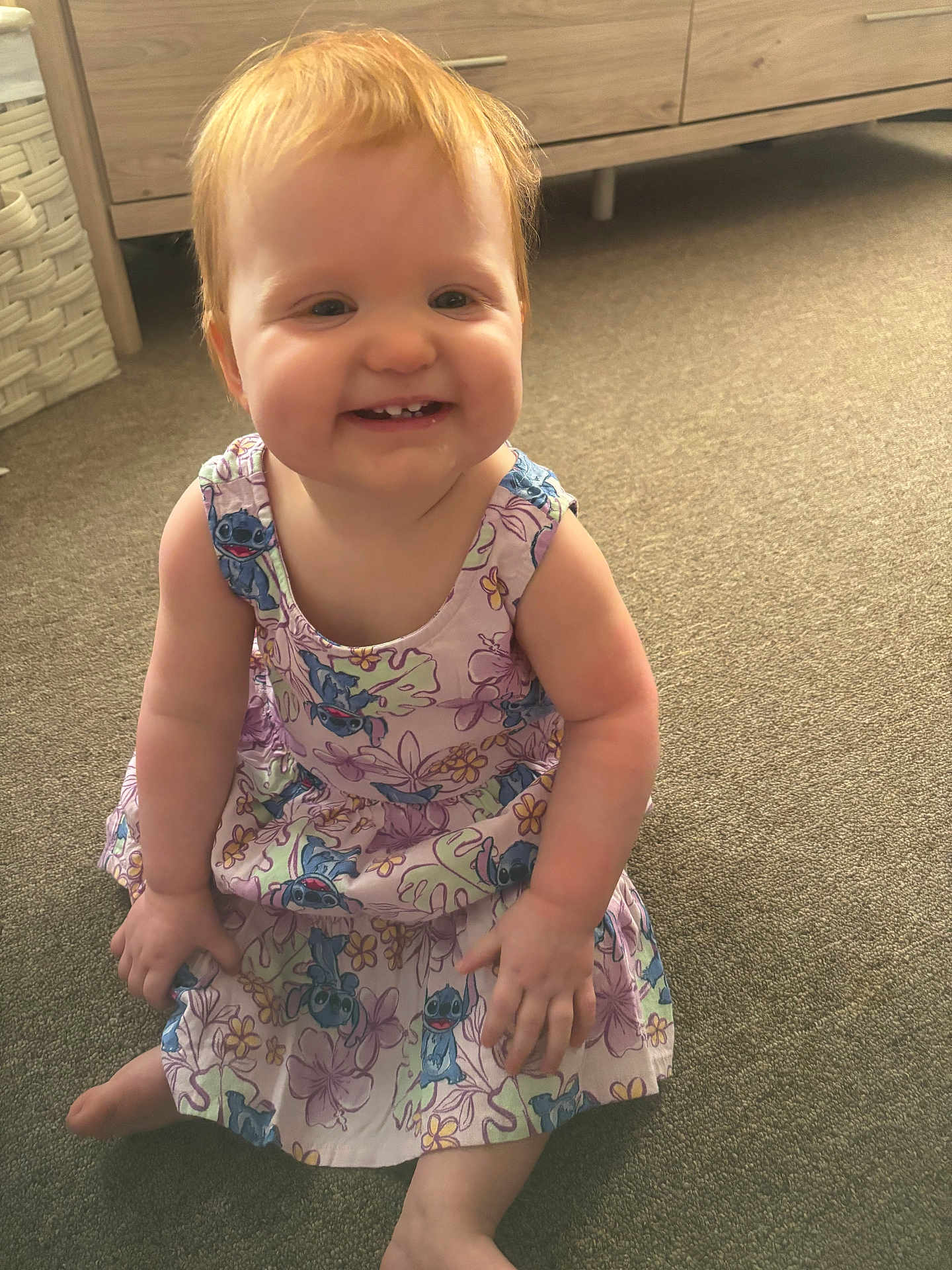 Kasey joined the competition — help win amazing prizes! toddler, child, smiling, red_hair, dress, cartoon_print, sitting, carpet, indoor, happy, cute, person, baby, young_child, playful, bright, toothy_grin, furniture, wooden_drawer, basket
