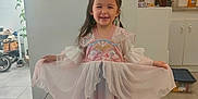 Naé participe au concours pour gagner de l'argent avec cette photo : appliance, cabinet, child, curtain, dress, footwear, girl, gown, happy, home, indoor, kitchen, light, long_hair, person, pose, princess, smile, tiara, tile_floor