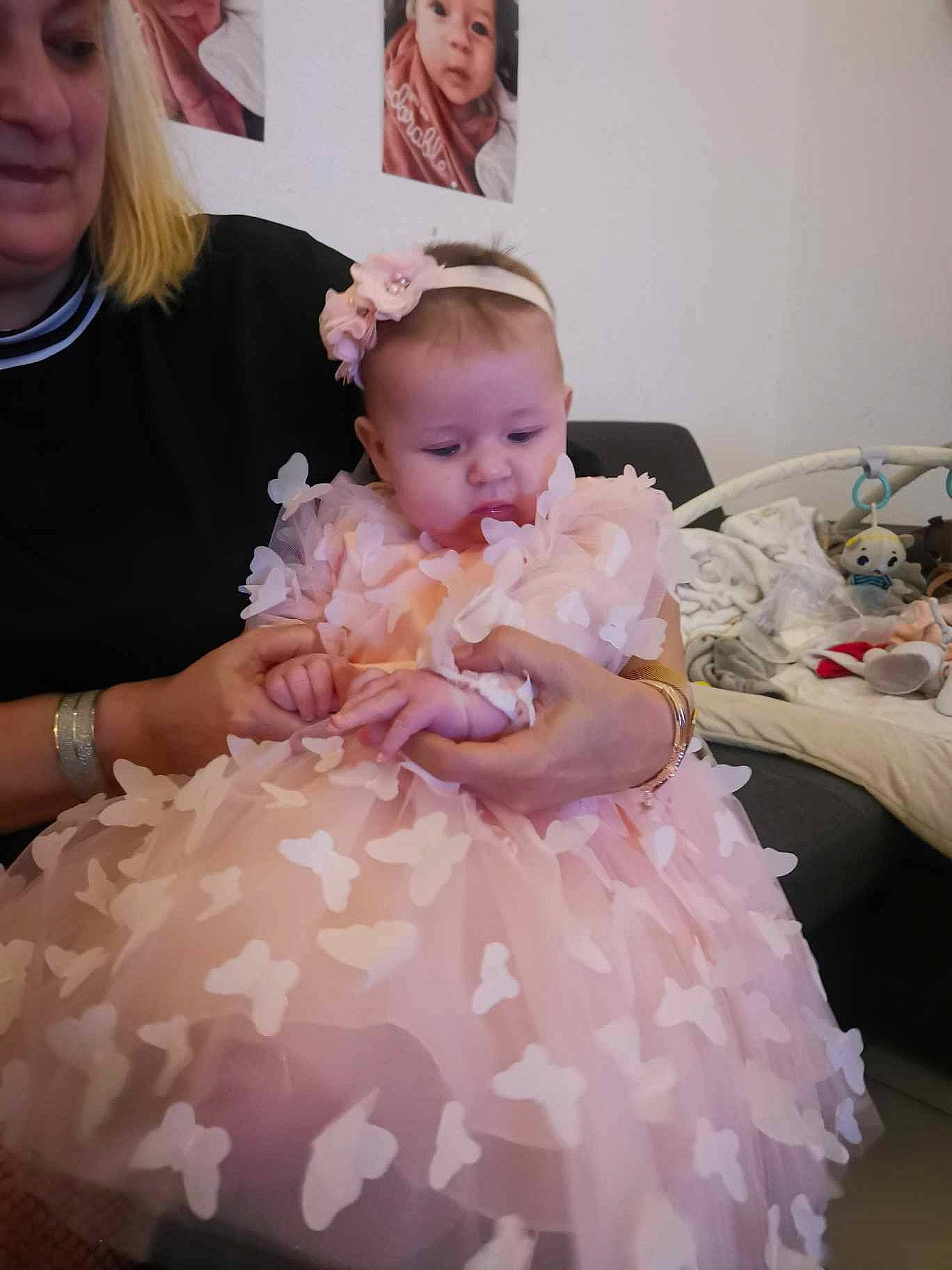 Ilona participe au concours pour gagner de l'argent avec cette photo : baby, baby_toddler_clothing, bridal_accessory, bridal_clothing, child, dress, embellishment, event, face, formal_wear, fun, gown, hair, happy, jewellery, peach, person, pink, sitting, toddler