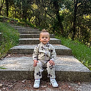 Daenerys participe au concours pour gagner de l'argent avec cette photo : child, toddler, steps, outdoor, forest, trees, greenery, nature, clothing, shoes, sitting, concrete, daylight, young_child, casual, fleece, paws, calm, curious, explorer