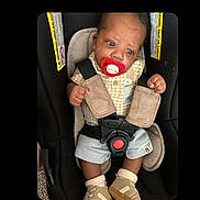A Zyiss joined the competition — help win amazing prizes! baby, infant, car_seat, pacifier, harness, safety_belt, seated, portrait, face, eyes, hands, shorts, shoes, clothing, indoor, vehicle, child,  안전, closeup, photograph