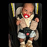 baby, infant, car_seat, pacifier, harness, safety_belt, seated, portrait, face, eyes, hands, shorts, shoes, clothing, indoor, vehicle, child,  안전, closeup, photograph