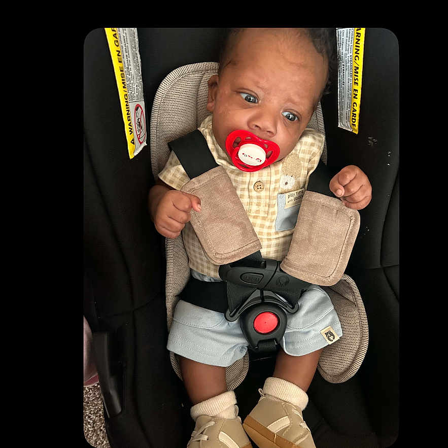 A Zyiss joined the competition — help win amazing prizes! baby, infant, car_seat, pacifier, harness, safety_belt, seated, portrait, face, eyes, hands, shorts, shoes, clothing, indoor, vehicle, child,  안전, closeup, photograph