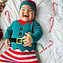 Loann participe au concours pour gagner de l'argent avec cette photo : baby, child, smiling, holiday, christmas, elf_costume, candy_cane, gift, striped_pants, red_hat, green_and_red, white_blanket, happy, festive, cute, lying_down, holiday_season, present, celebration, portrait