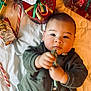 Loann a rejoint le concours — aidez-le/la à gagner de superbes lots ! baby, infant, child, face, hand, toy, candy_cane, gift, present, holiday, christmas, blanket, clothing, green_jacket, red, gold, ribbon, wrapped_gift, cute, indoor