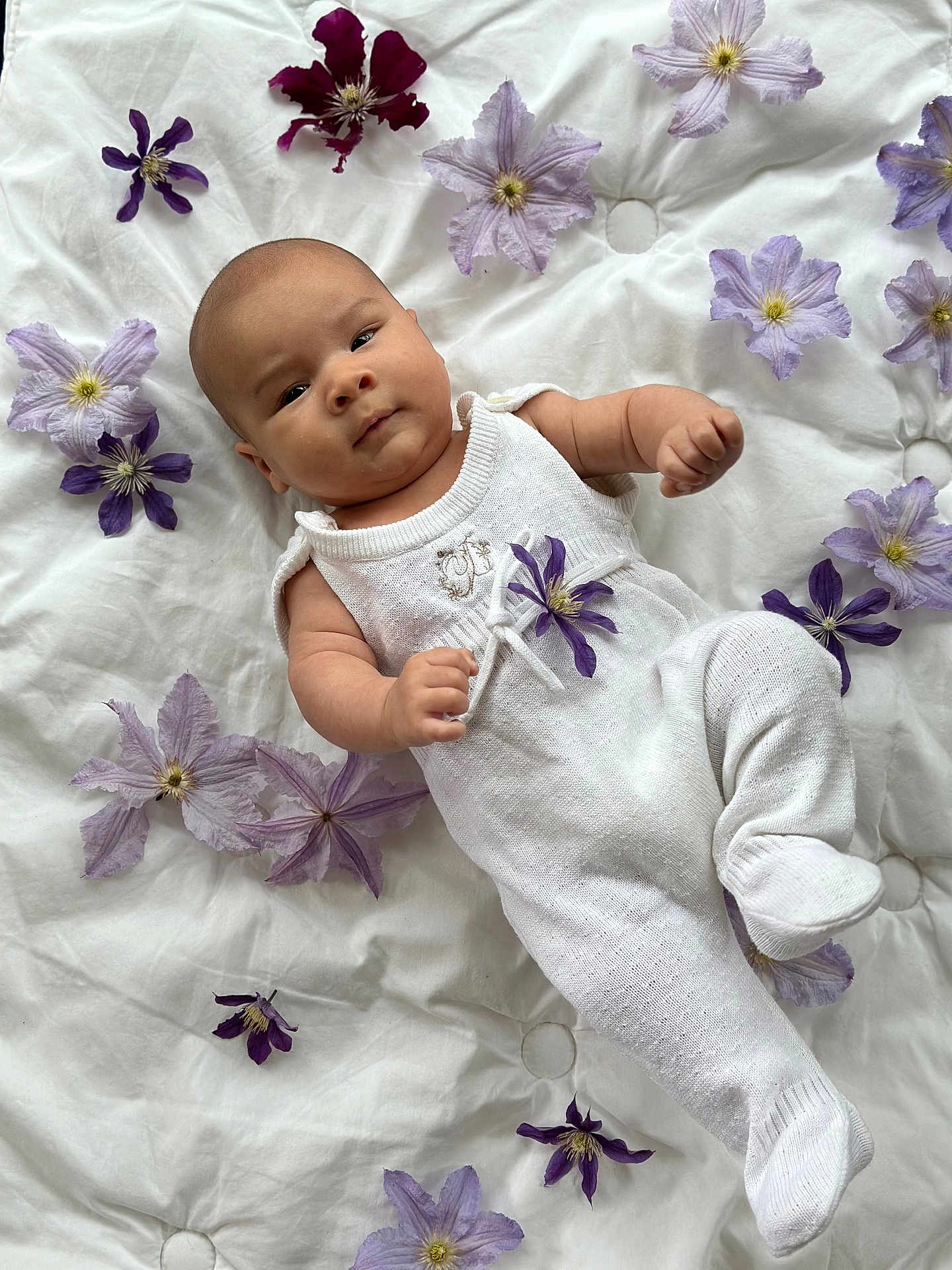 Loann participe au concours pour gagner de l'argent avec cette photo : baby, infant, white_outfit, purple_flowers, blanket, lying_down, cute, soft_lighting, peaceful, portrait, child, newborn, floral_arrangement, indoors, sleepwear, skin, person, closeup, adorable, cozy