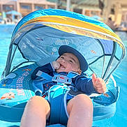 Dezi is registered to the contest to win money with this photo: baby, blue, canopy, child, float, happy, hat, infant, outdoor, playful, relaxing, safety_harness, smile, summer, sunlight, swimming_pool, swimwear, thumbs_up, vacation, water