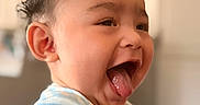 Dezi joined the competition — help win amazing prizes! baby, blurred_background, child, cute, expression, face, hands, happy, head, indoor, infant, joy, light, person, portrait, short_hair, skin, smiling, striped_shirt, tongue_out