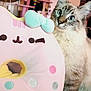 Pusheen joined the competition — help win amazing prizes! cat, plush_toy, donut_pillow, blue_eyes, furry, whiskers, paws, curious, indoor, cozy, blanket, bed, cat_tree, pastel_colors, toy, portrait, close_up, furniture, soft_toy, cute