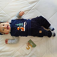 Amaury participe au concours pour gagner de l'argent avec cette photo : baby, infant, smiling, lying_down, clothing, cap, striped_shirt, socks, milestone_card, fox_design, tree_design, quilted_bedspread, white_background, cute, happy, child, portrait, indoors, cozy, casual