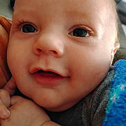 Reece is registered to the contest to win money with this photo: baby, closeup, face, eyes, smile, blanket, hand, cute, infant, skin, person, child, cozy, expression, portrait, young, warm, soft, happy, indoors