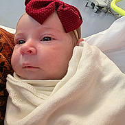 Autumn is registered to the contest to win money with this photo: baby, infant, face, headband, bow, blanket, wrapped, indoors, soft_texture, closeup, newborn, child, cute, skin, person, portrait, expression, warm, cozy, clothing
