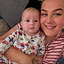 baby, child, woman, smile, face, pajamas, patterned_clothing, striped_clothing, couch, cushion, indoor, portrait, person, holding, happy, infant, seated, home, closeup, tattoo