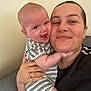 Logan is registered to the contest to win money with this photo: baby, adult, smile, happy, face, person, couch, striped_clothing, holding, indoor, skin, hand, head, cheek, love, family, casual, portrait, closeup, together