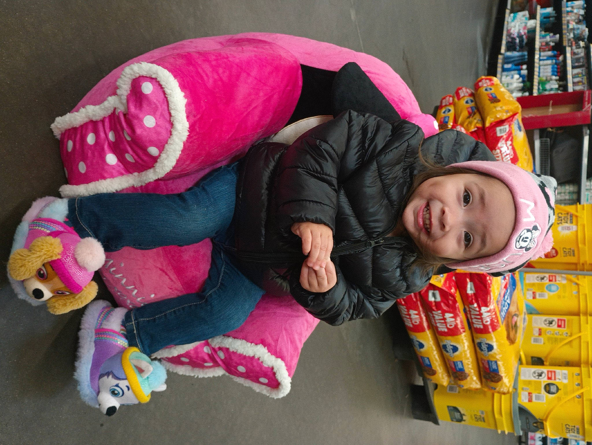 London is registered to the contest to win money with this photo: baby_toddler_clothing, carmine, child, comfort, event, fun, happy, headwear, joy, leisure, linens, magenta, person, pink, product, room, shelf, shelving, smile, stuffed_toy