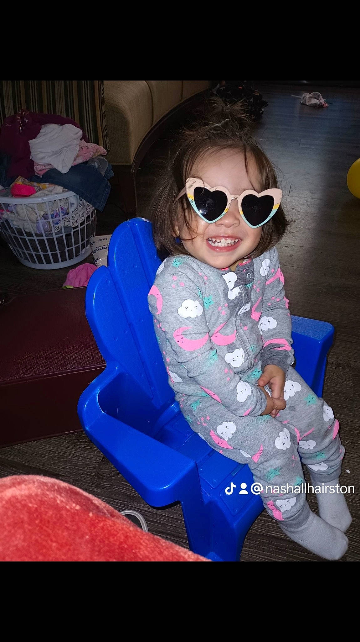 London is registered to the contest to win money with this photo: baby_toddler_clothing, child, cool, electric_blue, eyewear, fun, goggles, happy, joy, leisure, magenta, person, personal_protective_equipment, pink, purple, sitting, sleeve, smile, sunglasses, thigh