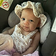 Marion is registered to the contest to win money with this photo: baby, baby_clothes, blanket, car_seat, chicco, child, clothing, cute, fabric, face, floral, hat, indoors, infant, person, pink, portrait, seat, smile, soft