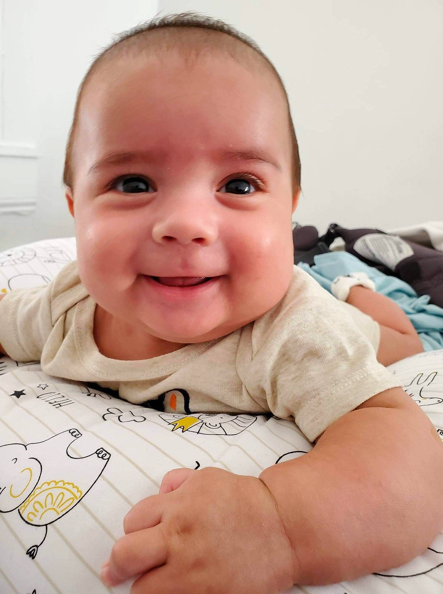 Emiliano is registered to the contest to win money with this photo: baby, baby_products, cheek, child, ear, eye, face, facial_expression, finger, forehead, head, joy, lip, mouth, nose, person, skin, smile, toddler, tummy_time