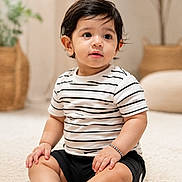 Atharv joined the competition — help win amazing prizes! toddler, child, baby, striped_tshirt, black_shorts, sitting, carpet, indoor, home_decor, plant, curly_hair, cute, portrait, soft_light, natural_light, expression, furniture, floor, skin, smile