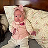 Layla is registered to the contest to win money with this photo: baby, infant, child, portrait, sitting, pink_bow, headband, pink_clothing, onesie, floral_pillow, bed, couch, indoors, face, eyes, rosy_cheeks, fashion, cute, photography, home