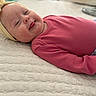 Layla is registered to the contest to win money with this photo: newborn, baby, infant, sleepy, smiling, lying_down, portrait, headband, bow, pink_clothing, floral_clothing, quilt, bed, bedding, indoor, close_up, face, cheeks, family_photo, cute