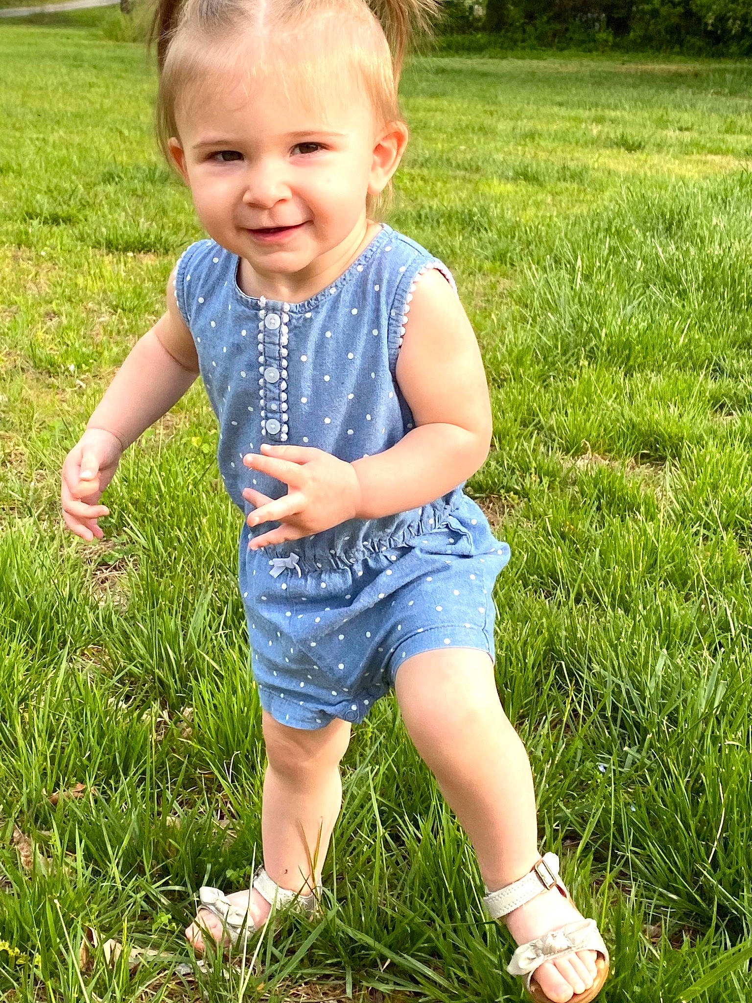 Emory is registered to the contest to win money with this photo: baby_toddler_clothing, fun, grass, grassland, green, groundcover, happy, joy, leaf, meadow, people_in_nature, person, photograph, plant, shorts, skin, smile, standing, summer, sunlight