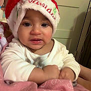 Emily joined the competition — help win amazing prizes! baby, child, christmas_hat, cozy, cute, eyes, face, festive, hands, holiday, indoor, infant, navidad, person, pink_blanket, portrait, red_hat, smile, warm, white_clothing