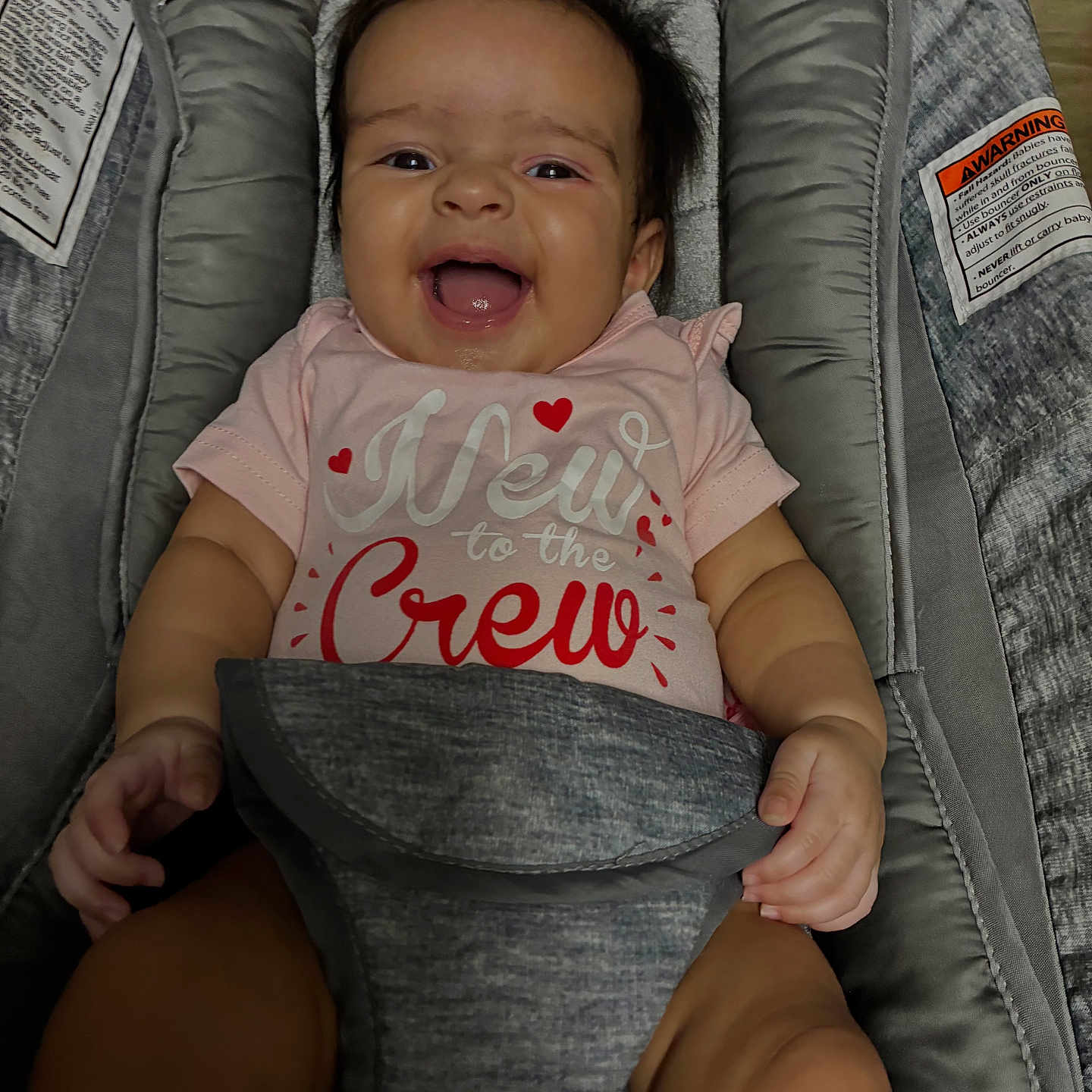Izzariah joined the competition — help win amazing prizes! baby, infant, child, smiling, happy, portrait, face, open_mouth, brown_hair, pink_clothing, onesie, heart_pattern, baby_seat, car_seat, cushion, indoor, sitting, close_up, photography, text_on_clothing