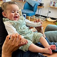 Aurore participe au concours pour gagner de l'argent avec cette photo : architecture, baby, bodypart, building, chair, clothing, couch, face, finger, furniture, hand, happy, head, indoors, livingroom, pants, person, photography, portrait, room
