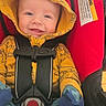 Caspian is registered to the contest to win money with this photo: baby, smile, hoodie, yellow_clothing, car_seat, red, mittens, blue_clothing, stars, moon, infant, child, happy, face, seatbelt, safety, cute, portrait, indoor, clothing