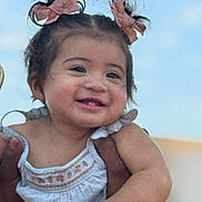 Milani joined the competition — help win amazing prizes! baby, child, smiling, girl, hair_bows, blue_sky, outdoor, cute, happy, portrait, person, hands, holding, clothing, white_dress, infant, face, skin, young, cheerful