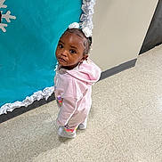 Taylee Greigh is registered to the contest to win money with this photo: toddler, child, pink_hoodie, curious_expression, indoor, floor_tiles, blue_backdrop, paper_snowflakes, wall, white_shoes, standing, person, young_child, floor, casual_clothing, headband, hair_accessories, small_child, looking_up, cute