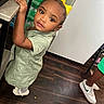 Taylee Greigh joined the competition — help win amazing prizes! toddler, child, yellow_bow, green_dress, curious, indoor, floor, wooden_floor, sneaker, person, recycling_bags, counter, hand, standing, looking, young_child, casual, clothing, footwear, home
