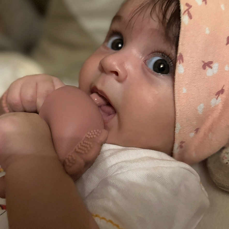 Anaya Maria is registered to the contest to win money with this photo: baby, chewing, child, closeup, clothing, curious, cute, expression, face, hand, hat, headwear, indoor, infant, person, portrait, skin, soft_toy, toy, young