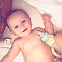 Lunna Rose is registered to the contest to win money with this photo: baby, smiling, bottle, diaper, blanket, bed, infant, happy, face, skin, arm, tattoo, lying_down, cute, child, person, indoors, soft_lighting, resting, young