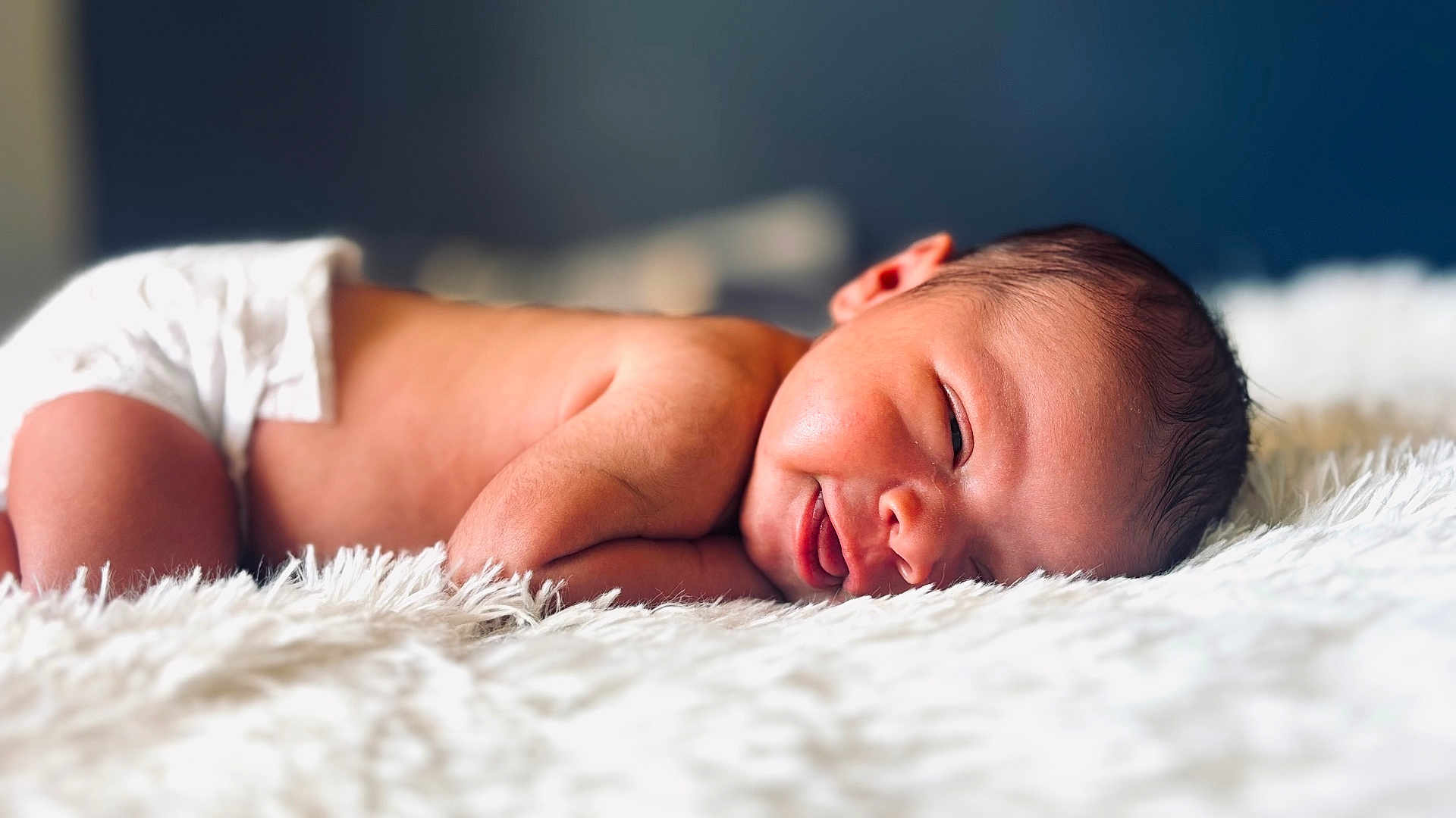 Kyzere is registered to the contest to win money with this photo: baby, newborn, infant, diaper, smile, smiling, sleeping, blanket, fur, bed, portrait, face, head, cute, cheek, skin, closeup, lying_down, soft_light, indoor