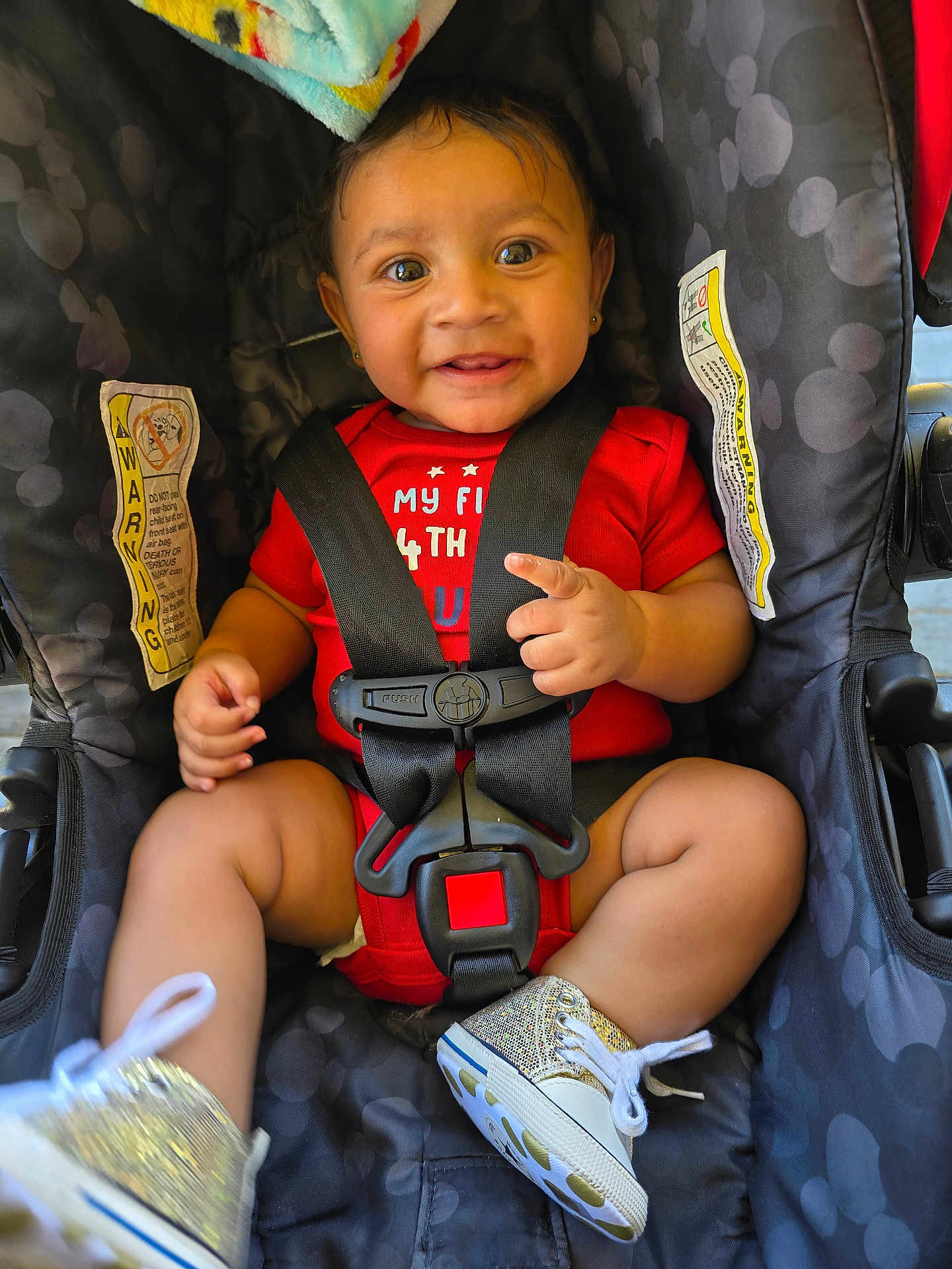 Monklare joined the competition — help win amazing prizes! baby, child, car_seat, smile, red_clothing, sparkly_shoes, sitting, happy, pointing, safety_harness, infant, cute, indoors, closeup, portrait, black_hair, skin, footwear, one_person, young_child