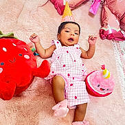 Zainab joined the competition — help win amazing prizes! baby, infant, pink_outfit, party_hat, plush_toy, strawberry_toy, cupcake_toy, blanket, soft_texture, celebration, cute, smiling_toy, lying_down, indoors, child, festive, colorful, happy, playful, cozy