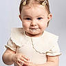 Giulyana participe au concours pour gagner de l'argent avec cette photo : toddler, child, baby, smile, face, hands, food, clothing, hair_clips, cute, messy, portrait, studio, white_background, innocent, playful, cheeks, eyes, collar, expression